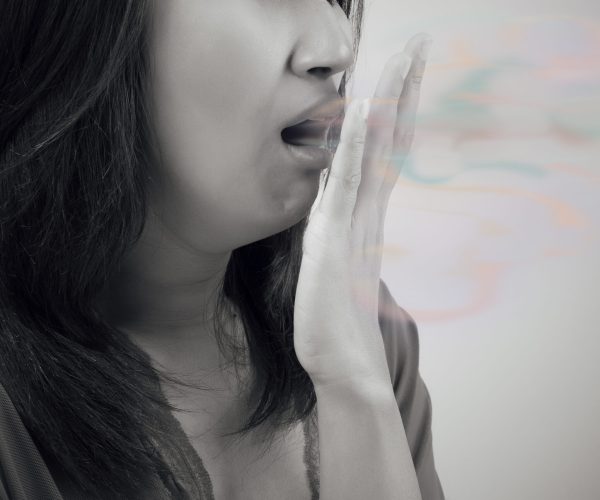 Asian woman close her mouth against gray background, Bad breath
