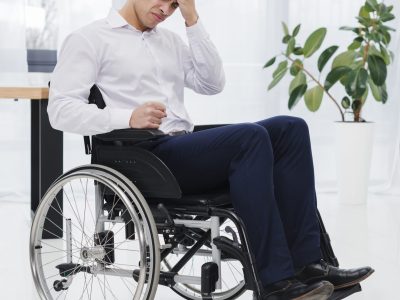 close-up-young-businessman-sitting-wheelchair-having-headache