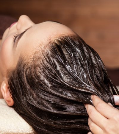 Cosmetologist massaging hair on the head of the woman. Spa treatments. Beauty treatment. Spa salon