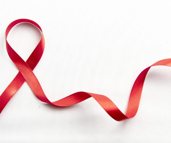 Red ribbon with white background. Hiv Aids ribbon awareness