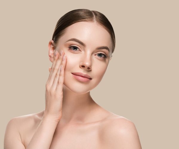 Skin care woman with hands portrait  skin closeup cosmetic age concept. Color background brown